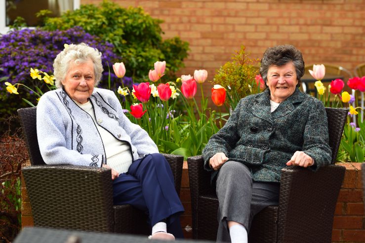 two care home residents sitting in a garden