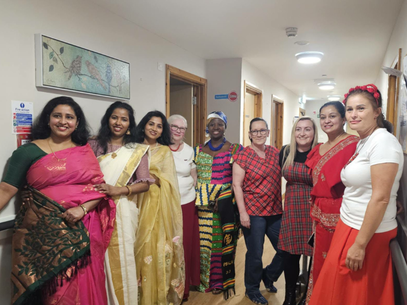 A collection of care home staff wear their native countries traditional dress as part of the care homes cultural fashion show 