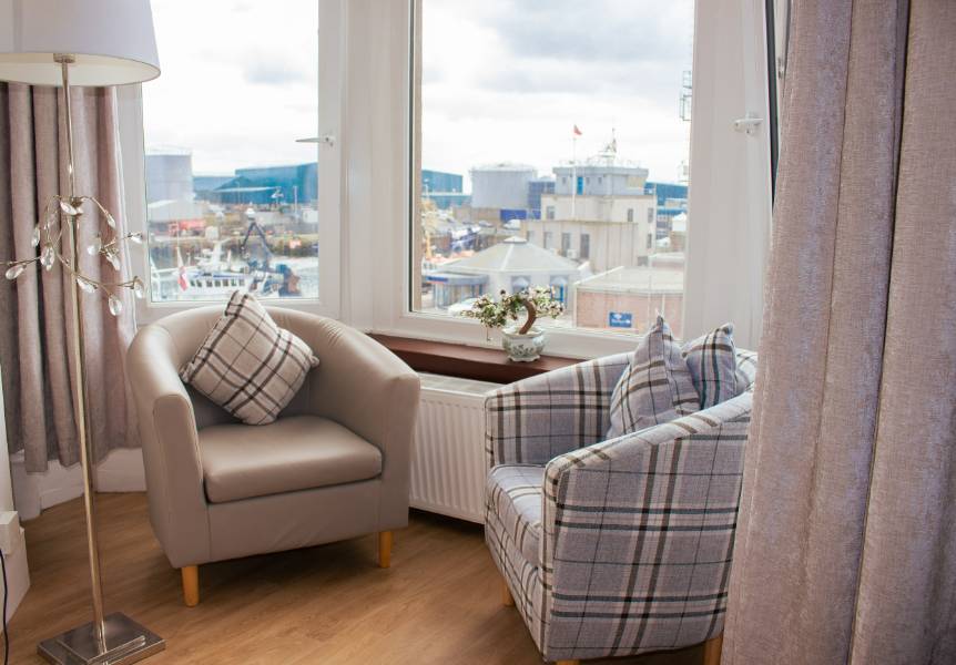 Peaceful window seat in a care home bedroom. The window offers a view of the harbour. 
