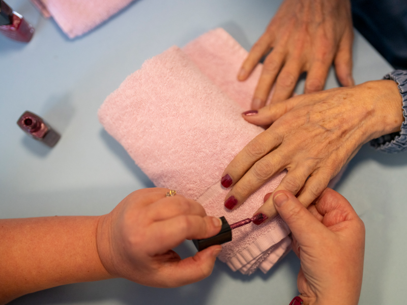 A staff member paints a care home residents nails