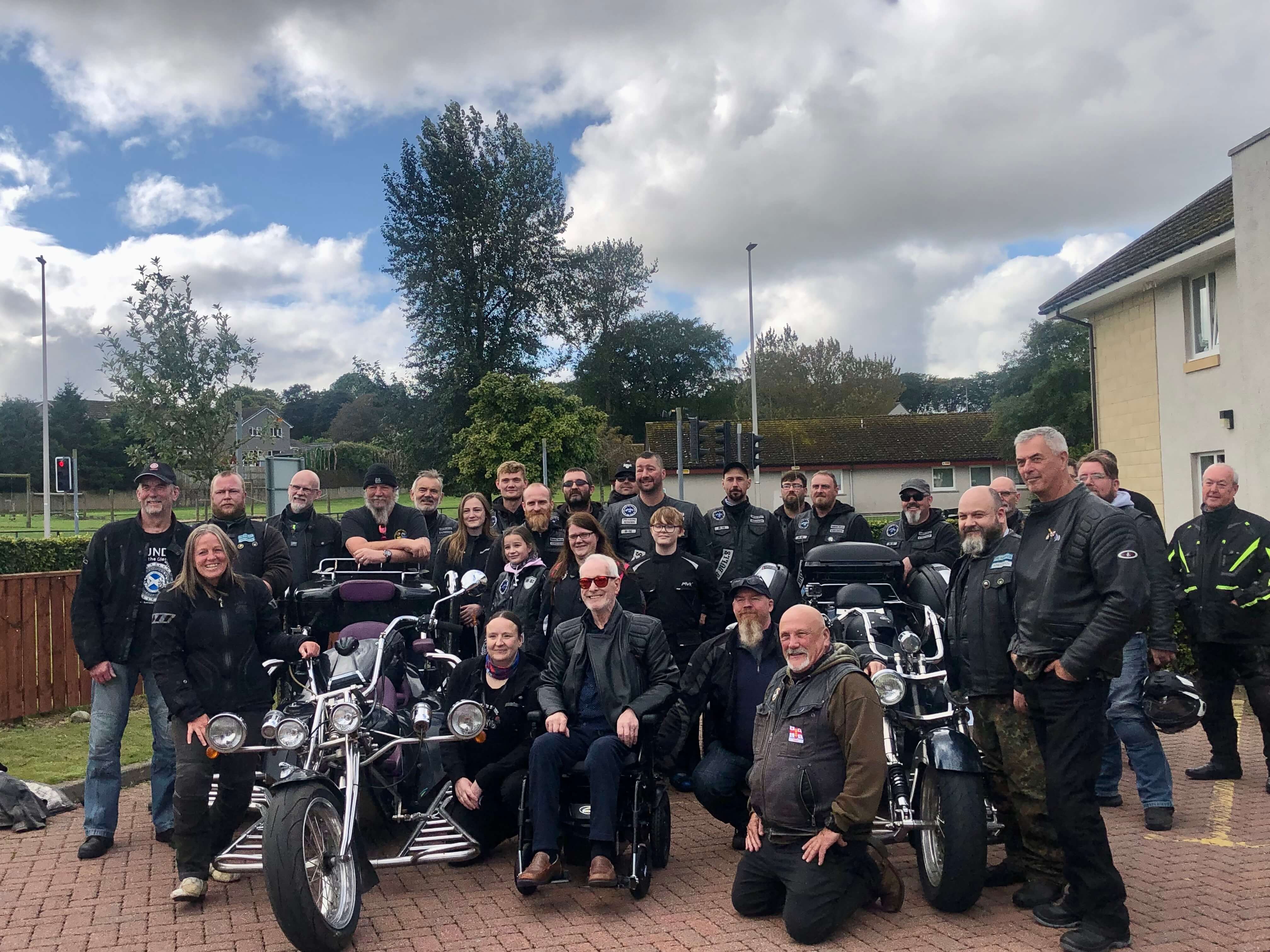 Care home resident Edwin surrounded by local bikers and motorcycles as he prepares for a thrilling biking adventure.