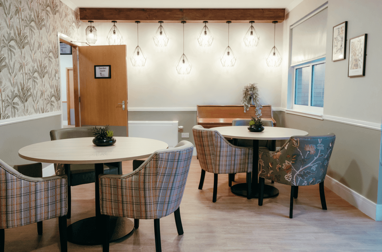 A bright and modern garden lounge - a spacious and bright room with multiple tables and chairs with a wooden piano and statement lighting