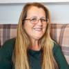 Headshot of care home manager, Annmarie Porter, She has long blonde hair, and is wearing a green blouse