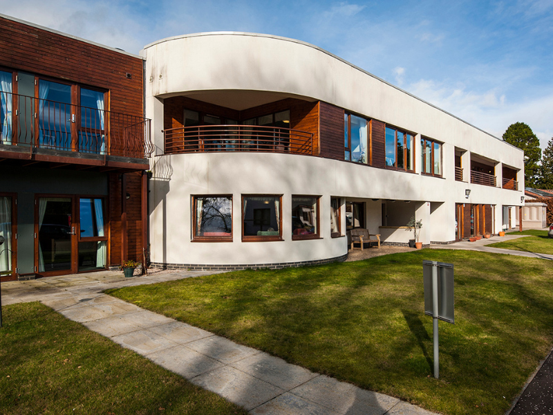 Beech Manor Care Home: Welcoming entrance with a white and wood exterior, balcony, and landscaped green space