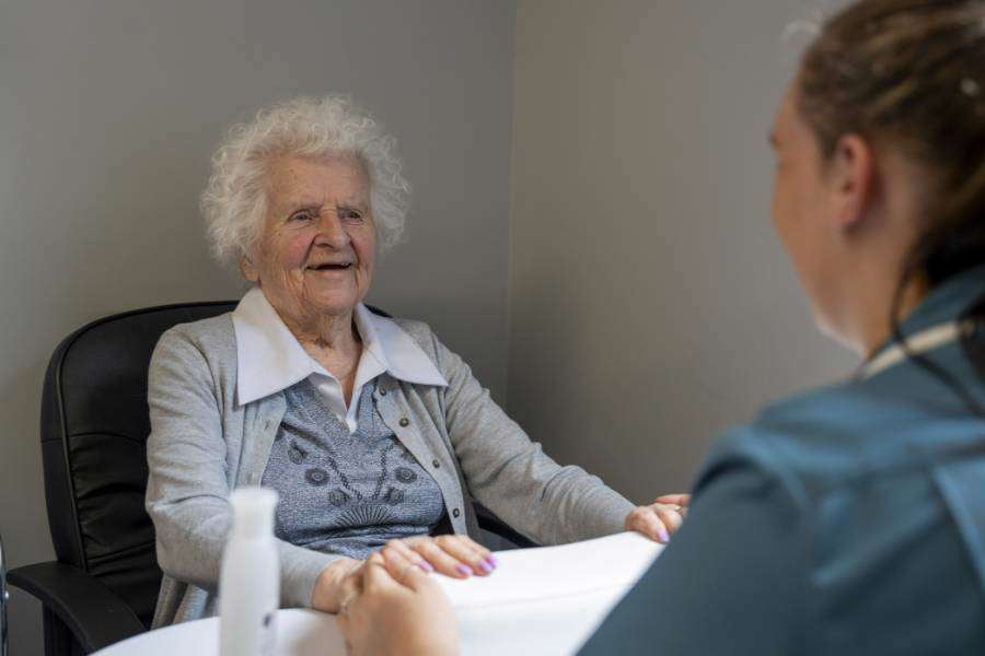 Care resident receives a manicure and smiles contentedly