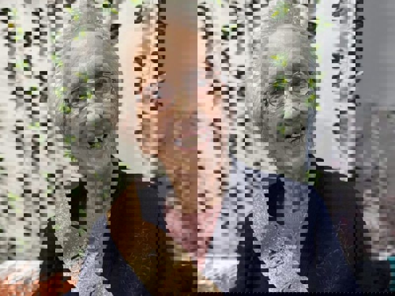 Nancy Lamb Celebrates her 100th Birthday. A head and shoulders shot of Nancy wearing a birthday sash and navy cardigan