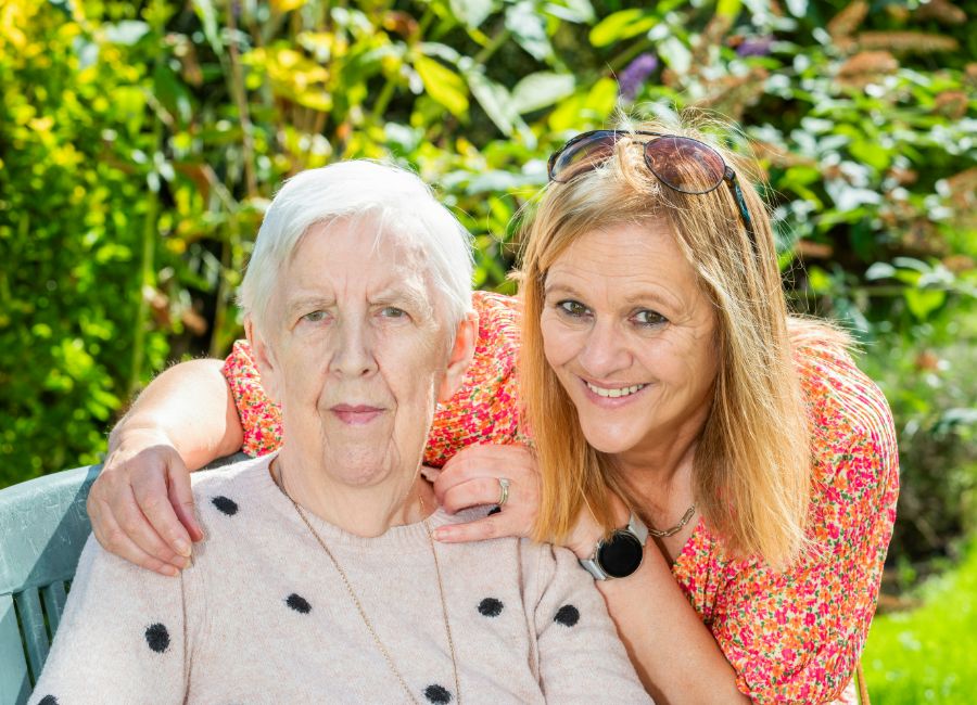 A family portrait of a visiting relative and their loved one enjoying time in the garden 