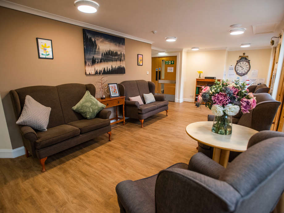 A communal space to sit and relax, there are an array of grey couches with various artworks and colourful decor