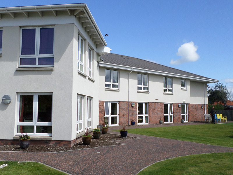 Berelands Exterior - a white and brick building sat within well-maintained grounds