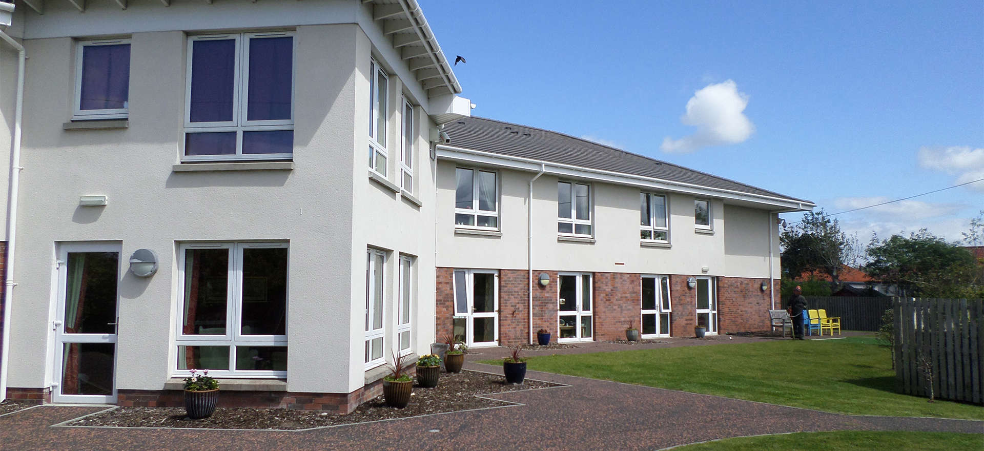 Berelands Exterior - a white and brick building sat within well-maintained grounds