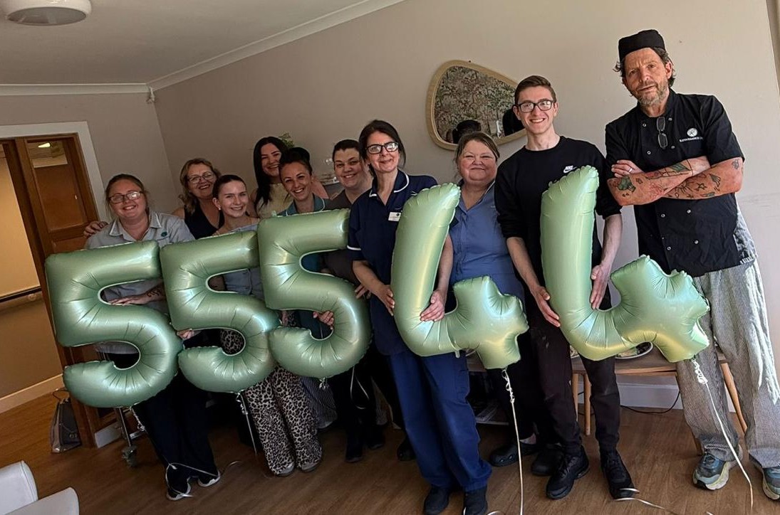 Several staff members stand with an assortment of gold '5' and '4' balloons reflecting recent care inspectorate grades