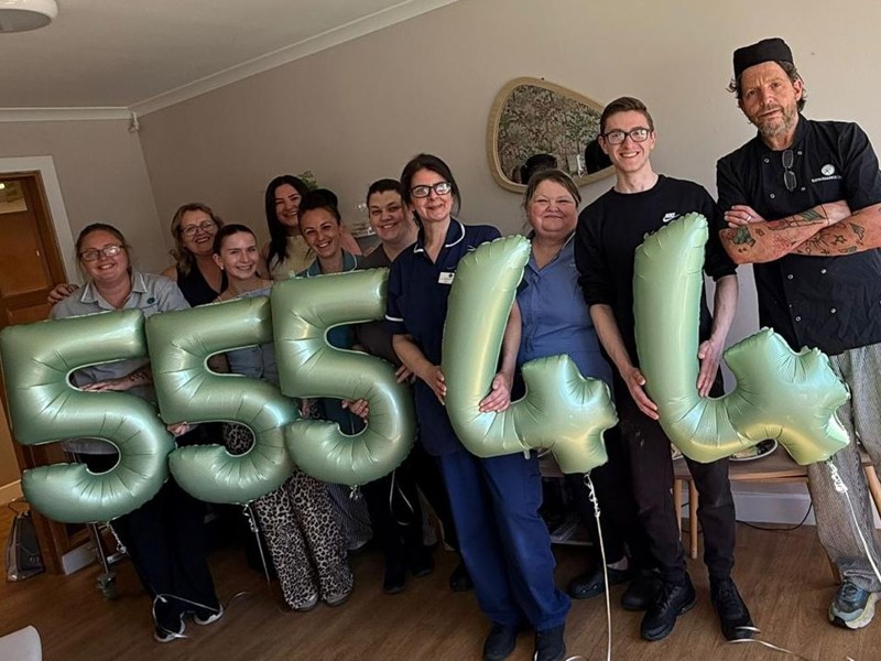 Several staff members stand with an assortment of gold '5' and '4' balloons reflecting recent care inspectorate grades